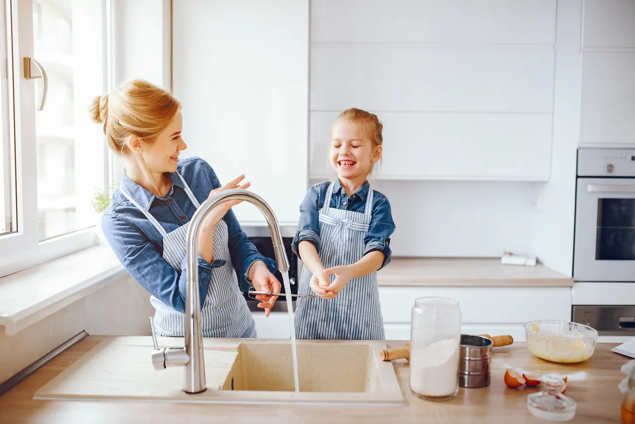 Mother enjoying a glass of water in her kitchen