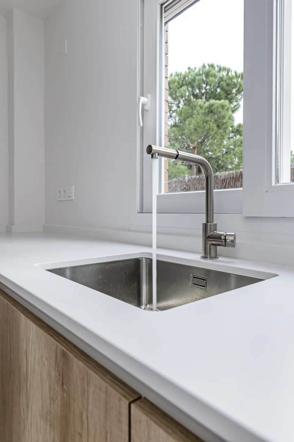 Filtered water running from a modern kitchen faucet