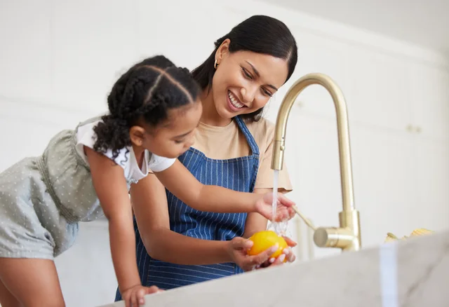 Mother and daughter washing produce with filtered water